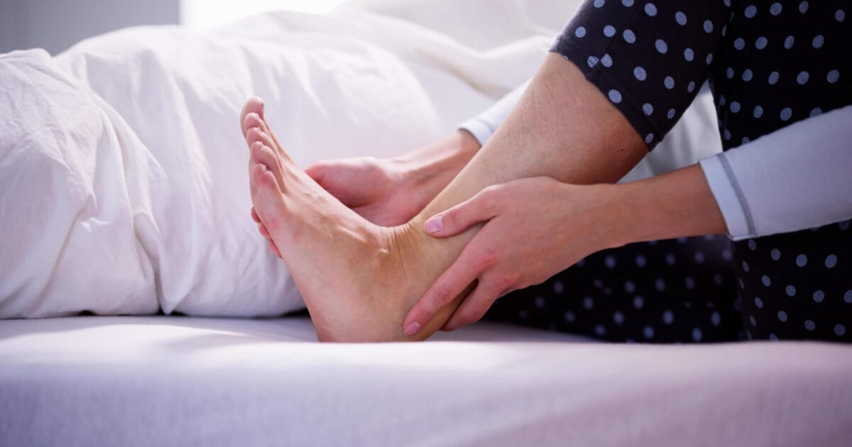 Aşil Tendonu Nedir? 1 Yatakta Aşil Tendonunu tutan bir kişi